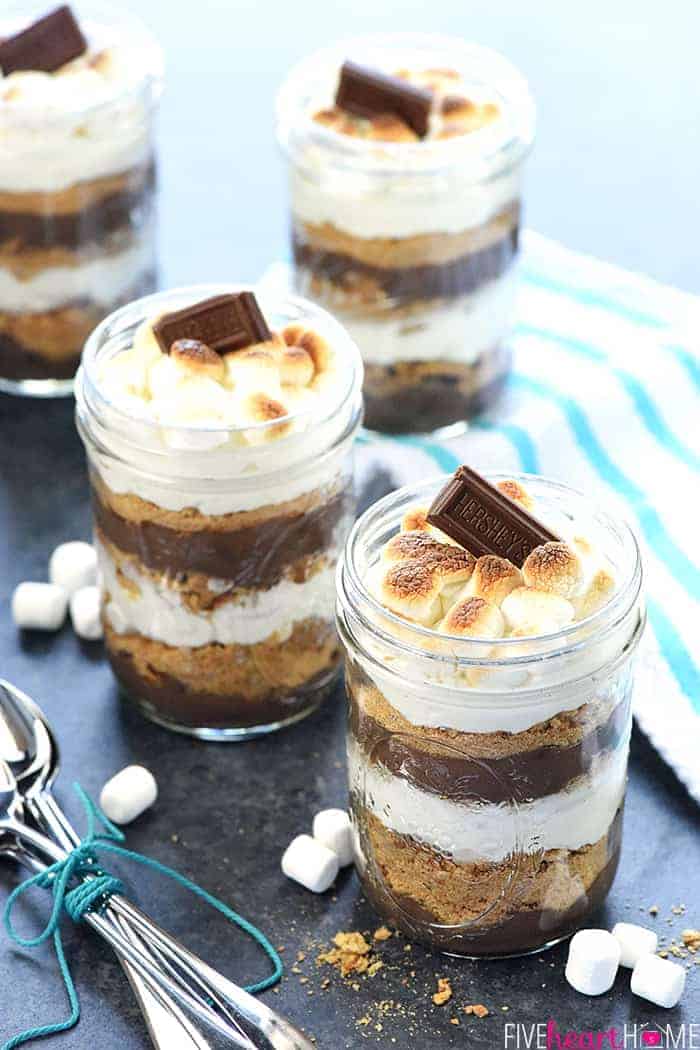 Mini S'mores Trifles in jars with spoons on table.