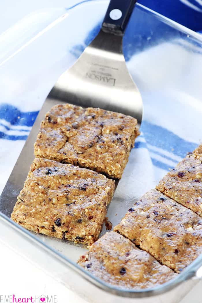 Energy Bars being scooped out of glass dish with spatula.