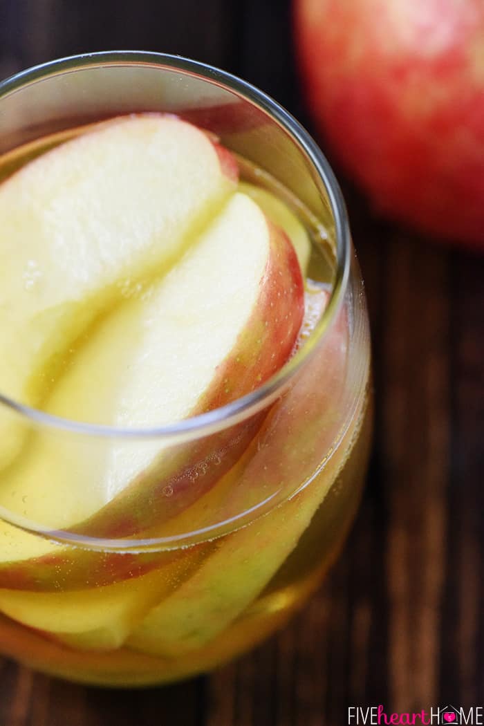 Sparkling Apple Cider Sangria ~ a festive fall cocktail recipe with just three ingredients -- white wine, apple cider, and sweet sliced Honeycrisps -- perfect for tailgating, Halloween, Thanksgiving, and even Christmas! | FiveHeartHome.com Aerial view of glass of Apple Cider Sangria