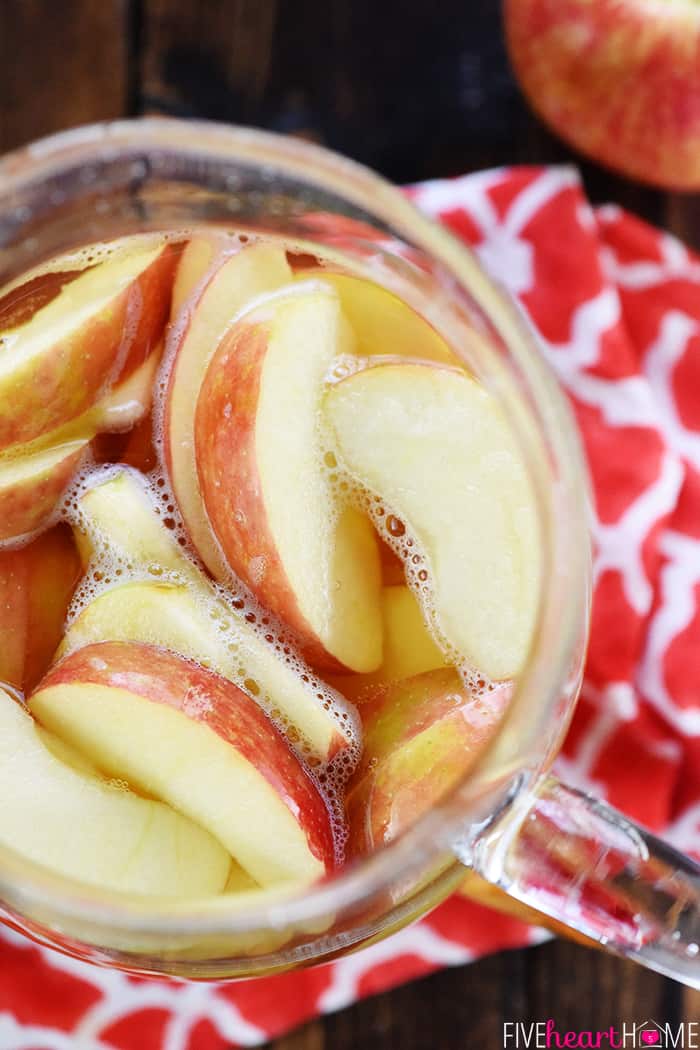 Sparkling Apple Cider Sangria ~ a festive fall cocktail recipe with just three ingredients -- white wine, apple cider, and sweet sliced Honeycrisps -- perfect for tailgating, Halloween, Thanksgiving, and even Christmas! | FiveHeartHome.com Aerial view of cocktail in pitcher