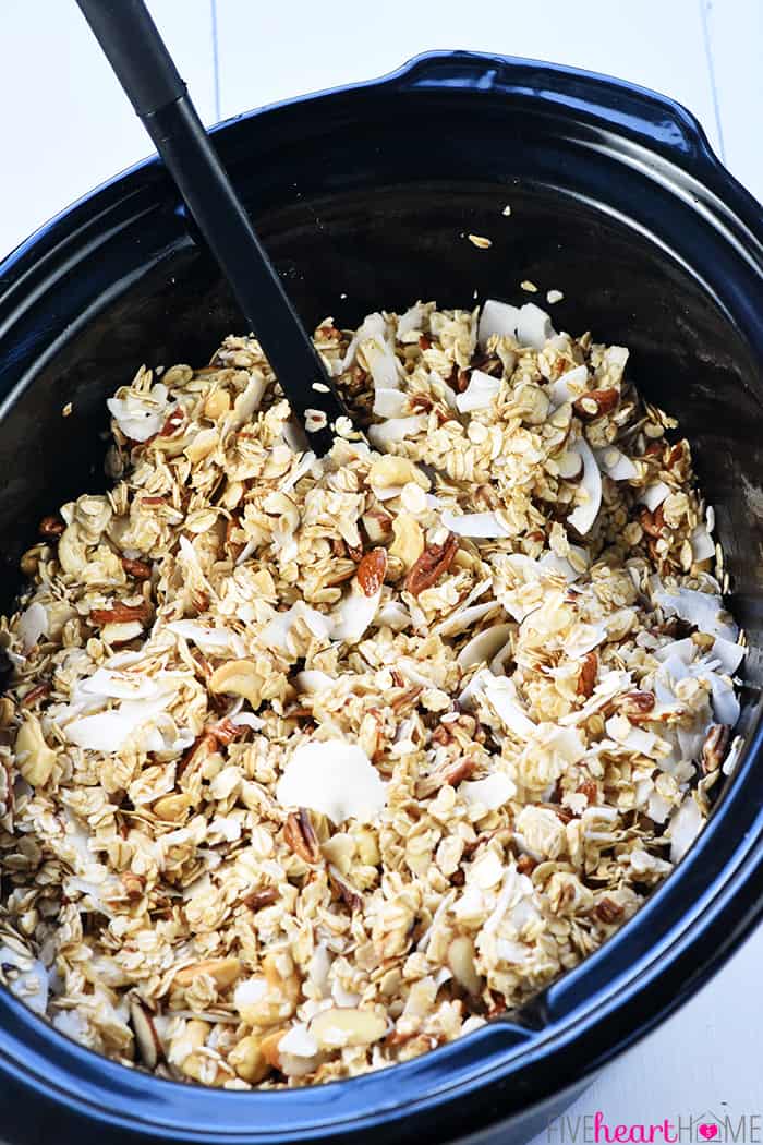 Mixing ingredients for Slow Cooker Granola in crock pot.