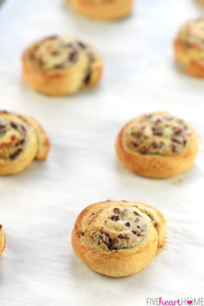 Close-up of Blue Cheese, Cranberry, & Pecan Crescent Pinwheels on baking sheet.