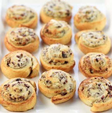 White serving tray of Blue Cheese Cranberry Pecan Crescent Pinwheels.