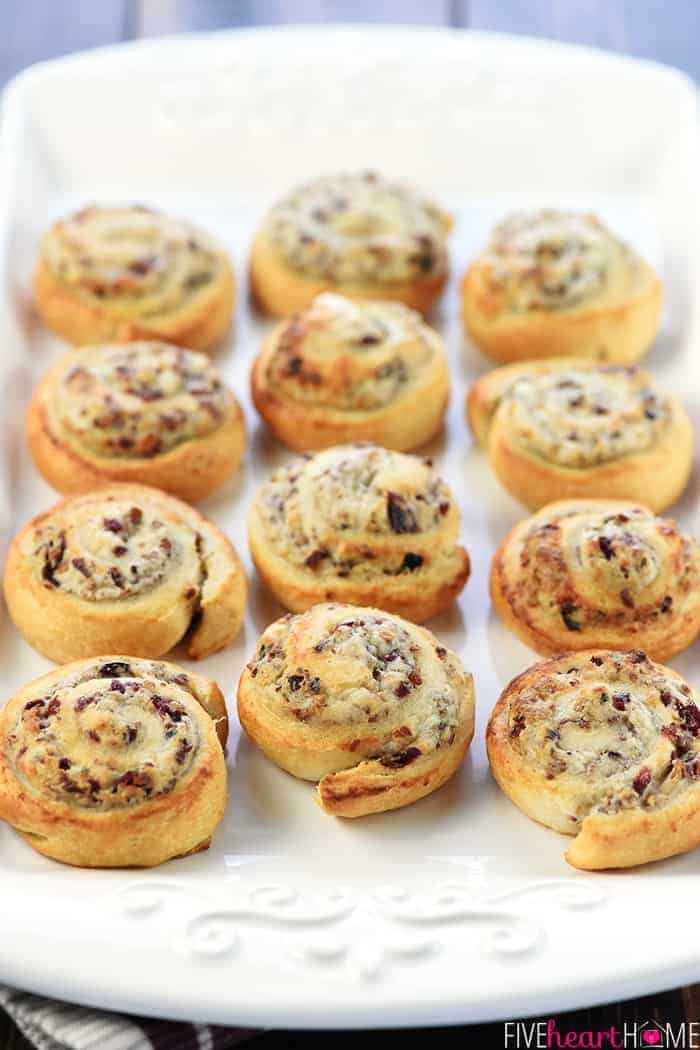 White serving platter filled with Blue Cheese Cranberry Pecan Crescent Pinwheels.