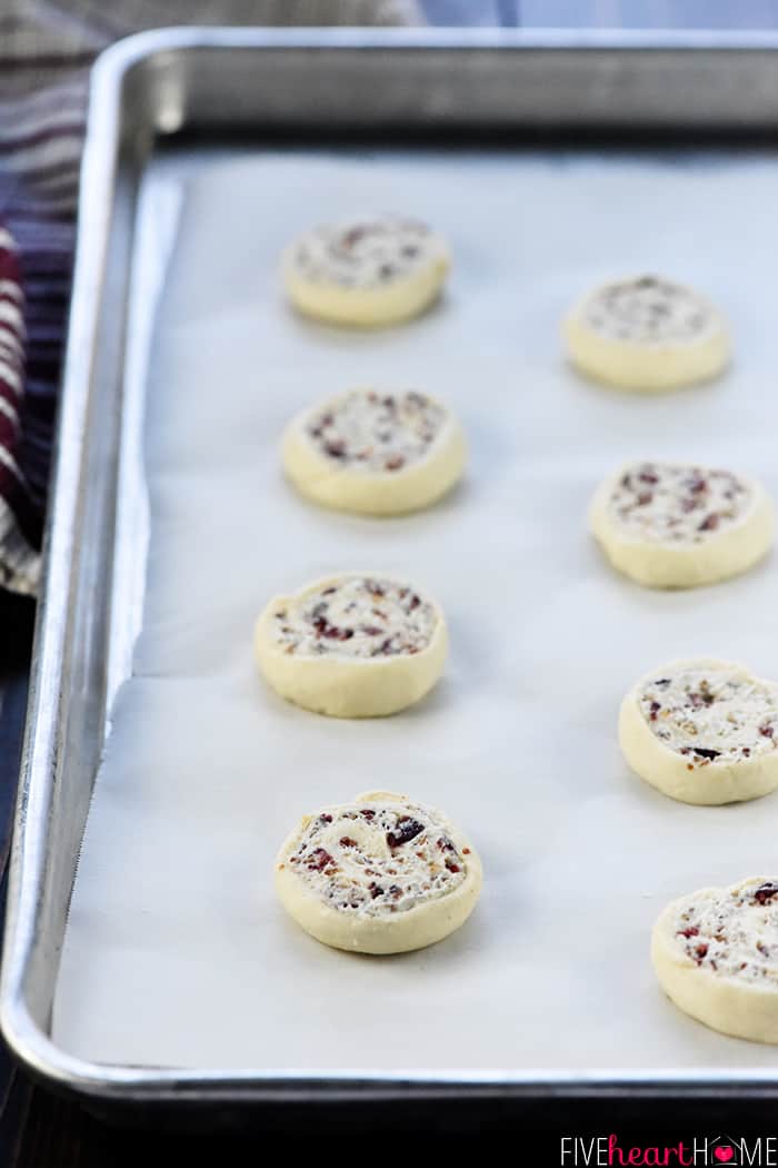 Unbaked crescent roll appetizers on baking sheert, ready for oven.