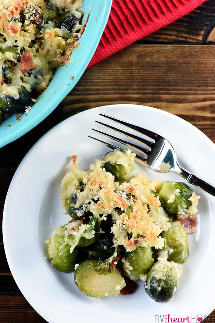 Brussels Sprouts with Bacon ~ a cheesy, decadent, delicious gratin recipe loaded with bacon, Gruyere, and crunchy breadcrumbs...the perfect side dish for dinner parties or holiday menus! | FiveHeartHome.com Aerial view of Brussels Sprouts Gratin dished onto white plate with fork.