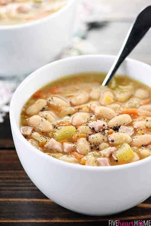 Crockpot Ham and Bean Soup in white bowl with spoon.