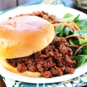 Closeup of the Best Sloppy Joe recipe, piled on a bun on a plate with sides.
