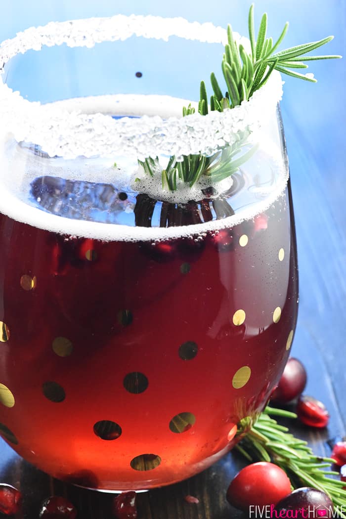 Easy Christmas Punch ~ a festive, sparkling, boozy holiday beverage featuring champagne, pomegranate juice, and cranberry juice that's perfect for Christmas or New Year's Eve parties...and it's easy to make a non-alcoholic version as well! | FiveHeartHome.com Close-up of Christmas Punch recipe in glass.