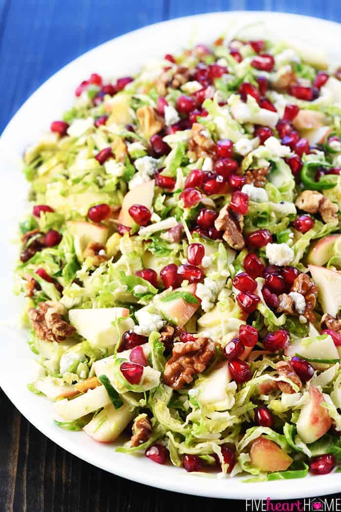 Shaved Brussels Sprouts Salad with apple and pomegranate on platter.
