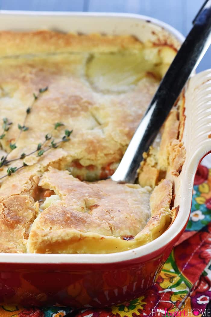 The BEST Chicken Pot Pie ~ features juicy chicken and tender veggies under a flaky, buttery crust for a delicious comfort food classic! | FiveHeartHome.com Best Chicken Pot Pie Recipe in Casserole with Serving Spoon