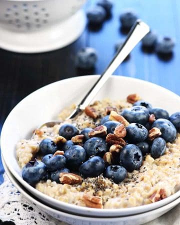 Steel cut oats in bowl with fresh blueberries and pecans.