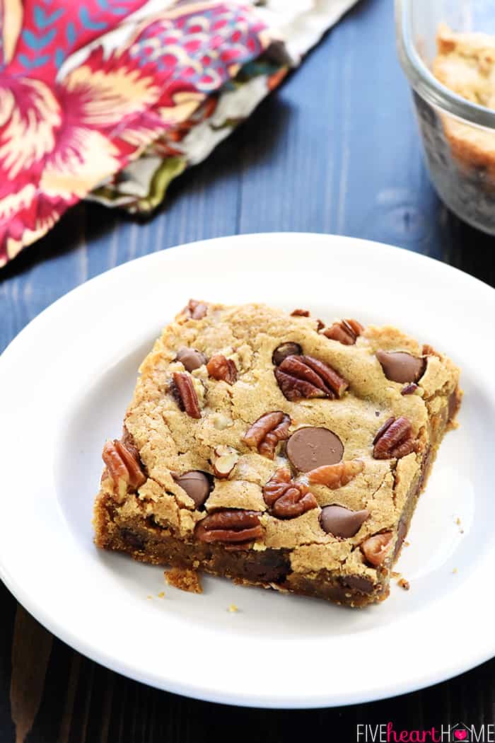 Blondie on plate with pecans and chocolate chips.