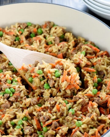 One-Pan Asian Ground Beef and Rice recipe in skillet with wooden spoon.
