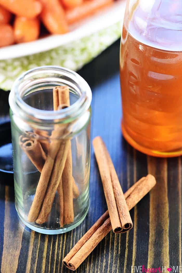 Close up of cinnamon sticks and bottle of honey.