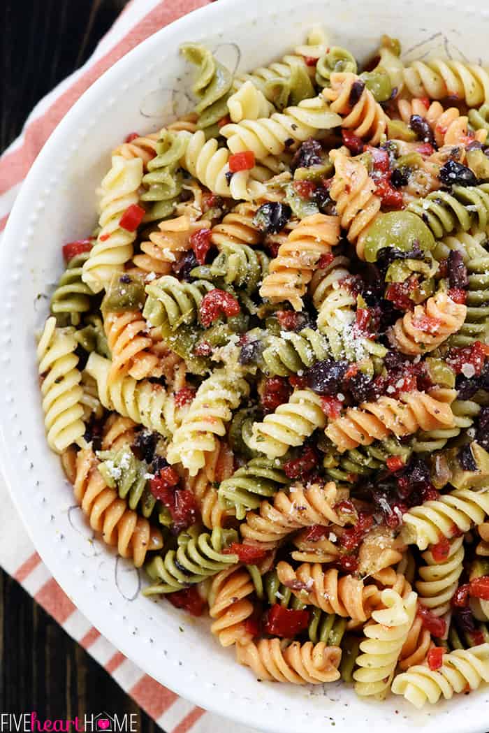 Easy Pasta Salad ~ tri-color garden rotini is studded with diced olives and pimentos, tossed with a zesty homemade Italian dressing, and showered with Parmesan for a versatile summer side dish recipe! | FiveHeartHome.com Aerial view of Easy Pasta Salad in serving bowl.