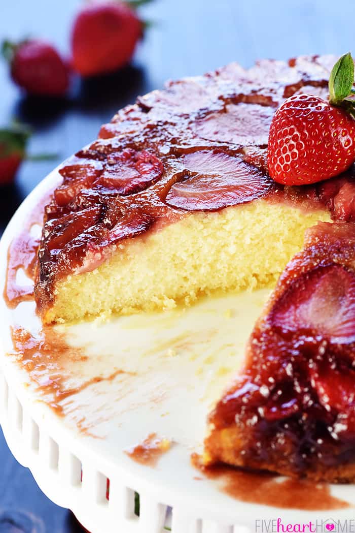 Strawberry Upside-Down Cake on cake stand with missing slice.