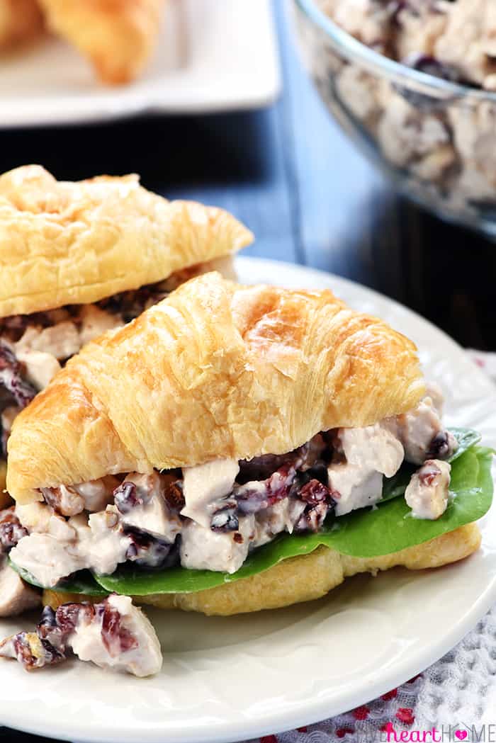 Sonoma Chicken Salad ~ studded with toasted pecans and dried cranberries in a lightened-up dressing including Greek yogurt & honey, this recipe makes scrumptious sandwiches for lunch, dinner, picnics, parties, or bridal and baby showers! | Five Heart Home.com Sonoma Chicken Salad sandwiches on plate.