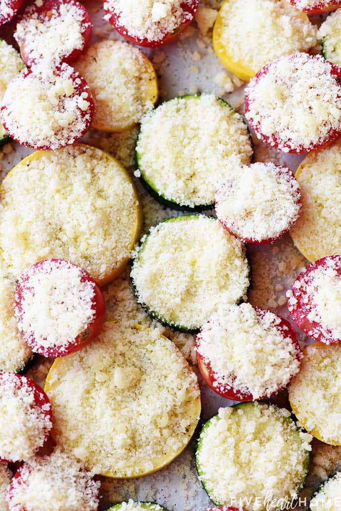 Parmesan generously sprinkled over sliced summer vegetable recipe.