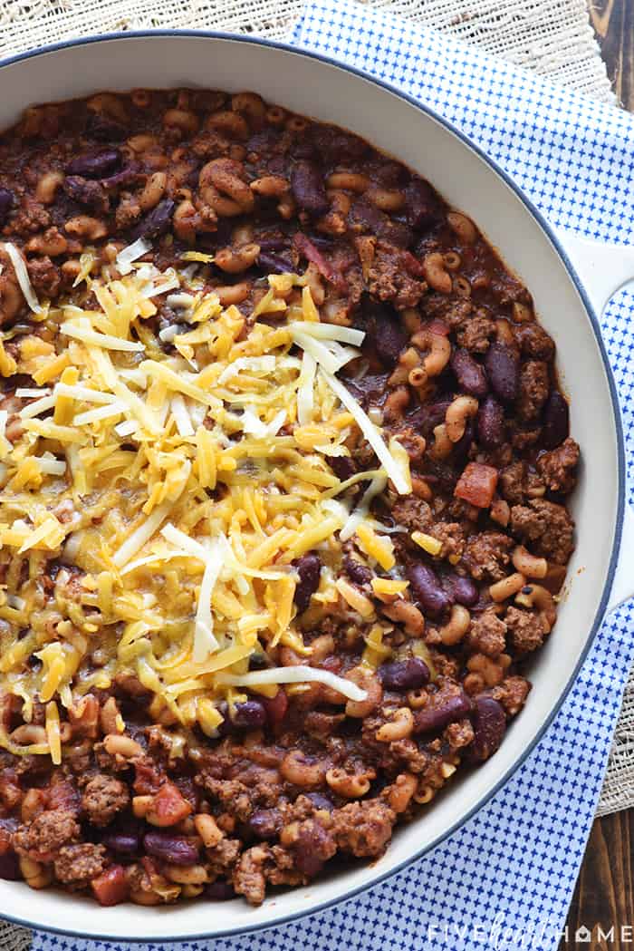 Overhead view of Chili Mac in skillet sprinkled with cheese.