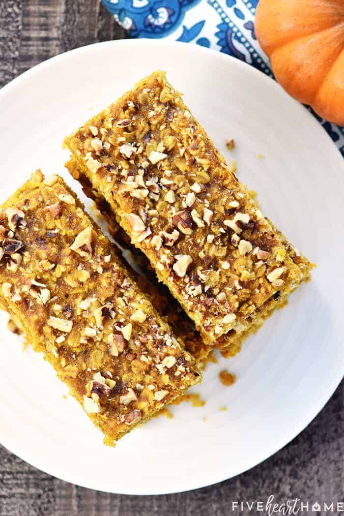 Healthy Pumpkin Breakfast Bars ~ soft-baked, chewy, and loaded with wholesome ingredients like oats, coconut oil, & honey for a grab-n-go breakfast or snack! | FiveHeartHome.com Aerial View of Pumpkin Oat Bars Stacked on White Platter