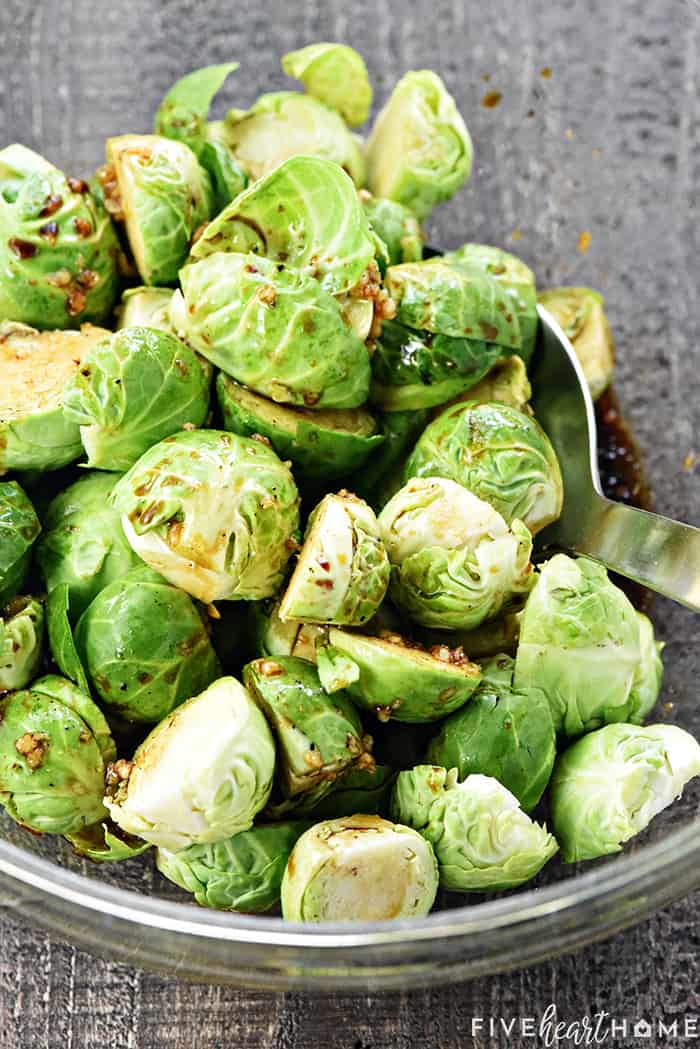 Close-up of Brussels Sprouts with Balsamic and garlic being stirred together.