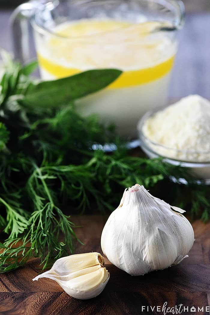 Ingredients on table including garlic and fresh herbs.