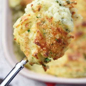 Make Ahead Mashed Potatoes, serving spoon held over dish.