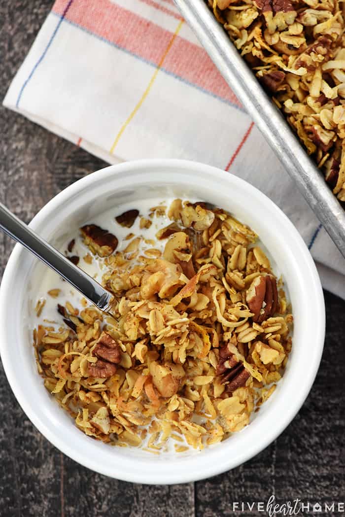 Healthy Pumpkin Granola ~ crunchy, golden, and easy to make, loaded with wholesome oats, toasty nuts, real pumpkin puree, coconut oil, maple syrup, & warm fall spices! | FiveHeartHome.com Served in White Bowl with Milk