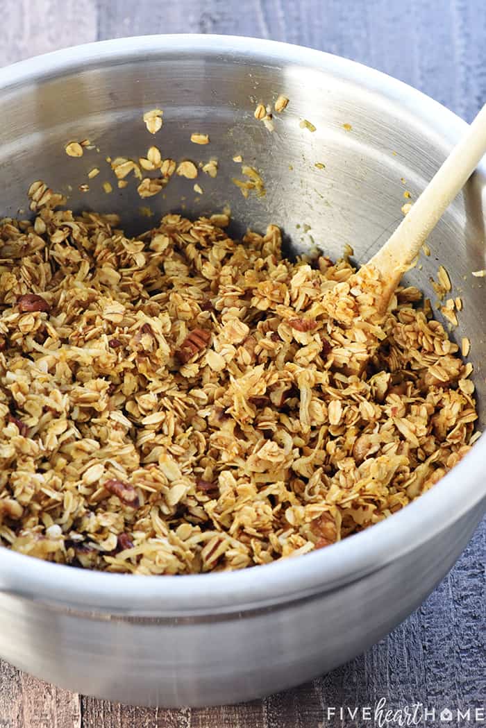 Healthy Pumpkin Granola ~ crunchy, golden, and easy to make, loaded with wholesome oats, toasty nuts, real pumpkin puree, coconut oil, maple syrup, & warm fall spices! | FiveHeartHome.com Ingredients in Mixing Bowl with Wooden Spoon