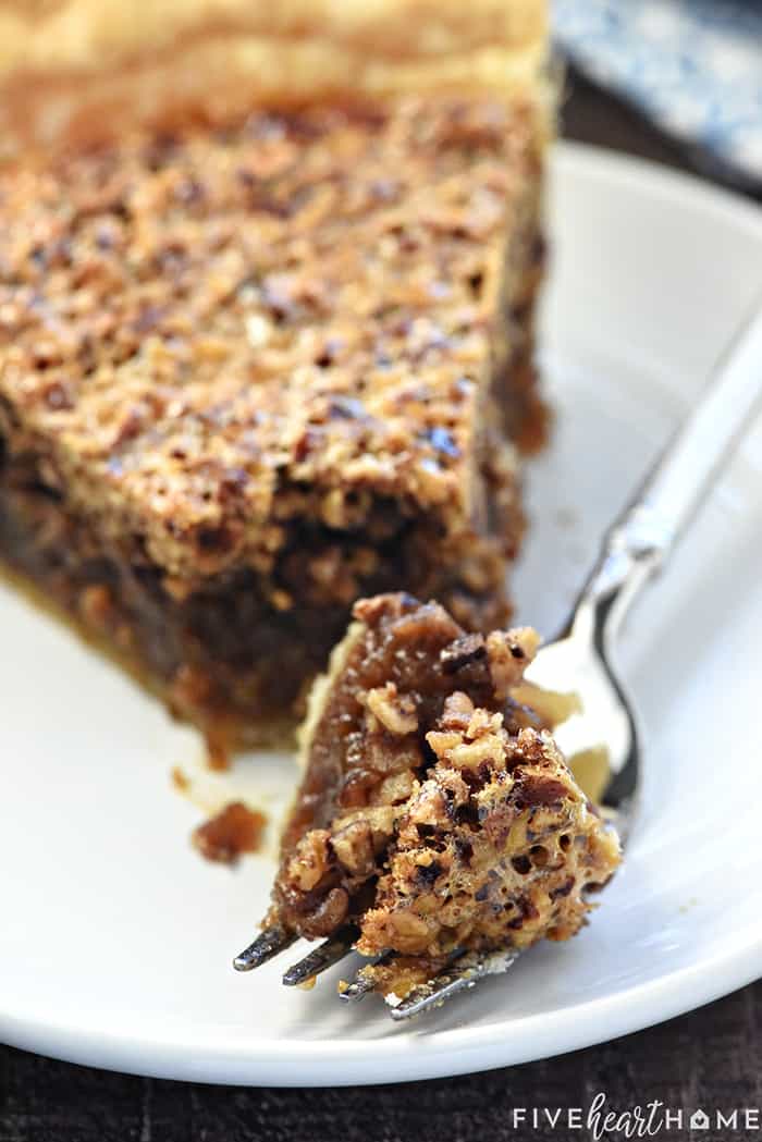 The BEST Pecan Pie ~ foolproof and perfect every time, with an abundance of toasty pecans floating on a thick, glossy filling in a flaky, all-butter pie crust! | FiveHeartHome.com Bite of Best Pecan Pie recipe on a fork.