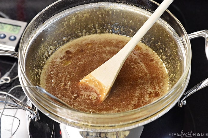 Filling cooking in double boiler with wooden spoon and thermometer. 