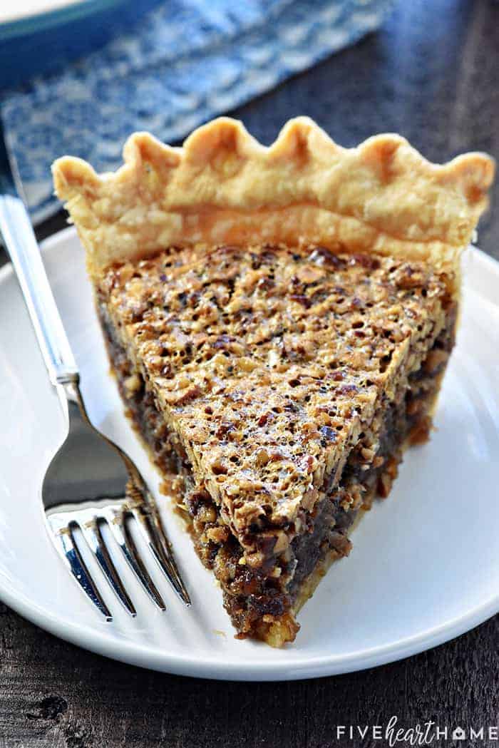 Slice of Best Pecan Pie on white plate with fork.