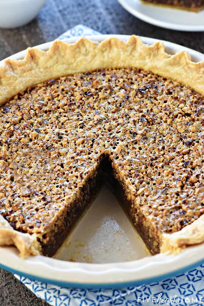 The BEST Pecan Pie ~ foolproof and perfect every time, with an abundance of toasty pecans floating on a thick, glossy filling in a flaky, all-butter pie crust! | FiveHeartHome.com One slice removed from dish.