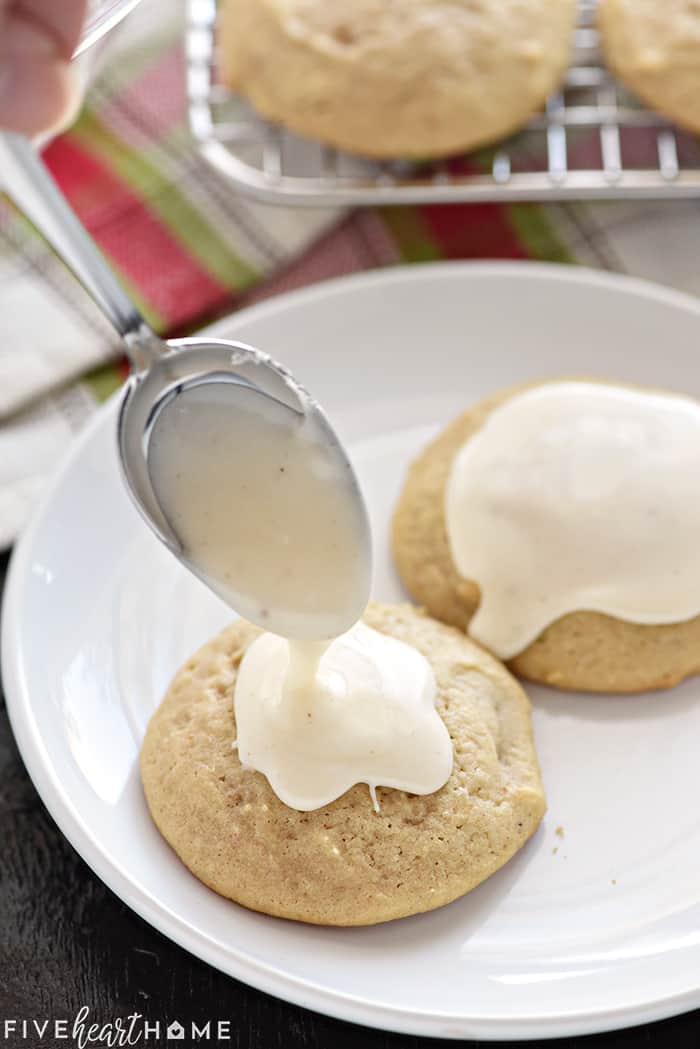Eggnog glaze being spooned onto Eggnog Cookies.