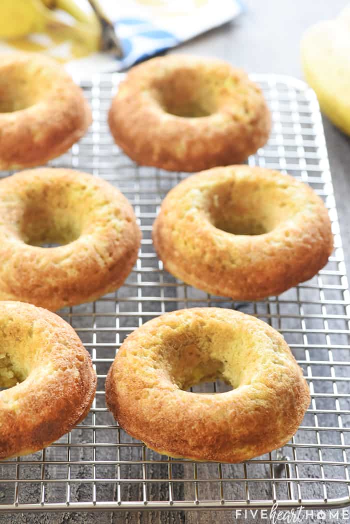 Baked Banana Donuts ~ soft, sweet, lightened-up, and easy to make, with your choice of a decadent chocolate glaze or a coating of cinnamon sugar! | FiveHeartHome.com Banana Donuts cooling on a wire rack