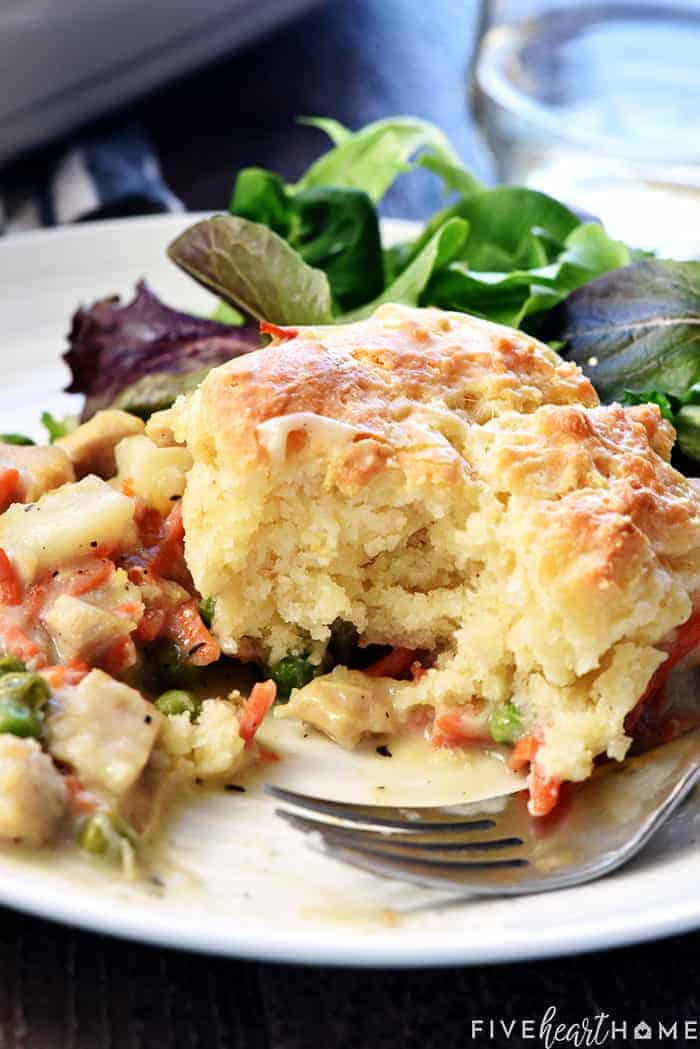 Chicken Pot Pie Casserole ~ this easy comfort food recipe features a classic filling of tender chicken, potatoes, carrots, and peas in a savory gravy topped with fluffy homemade drop biscuits! | FiveHeartHome.com Chicken Pot Pie Casserole on plate with bite missing.