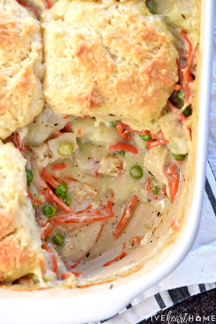 Chicken Pot Pie Casserole, aerial view of baking dish with biscuit missing.