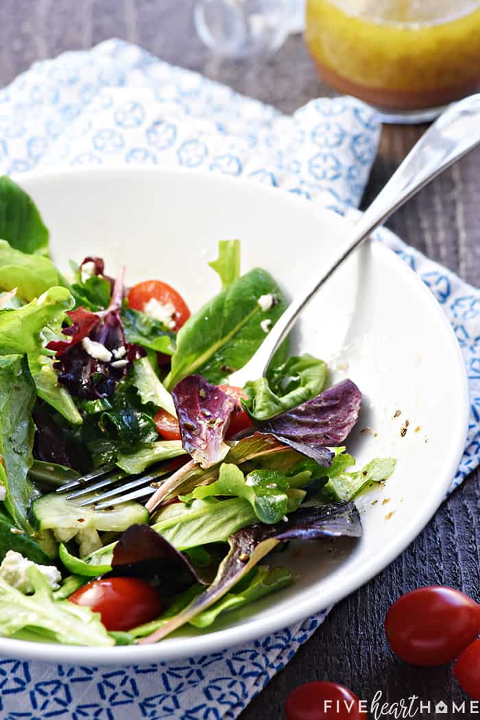 Bowl of lettuce, tomatoes, and cucumbers, half eaten.