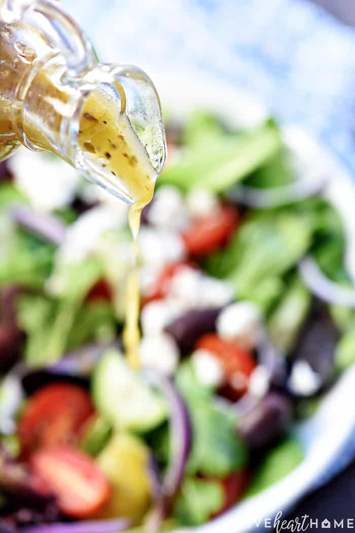 Authentic Greek Dressing being poured over a salad.