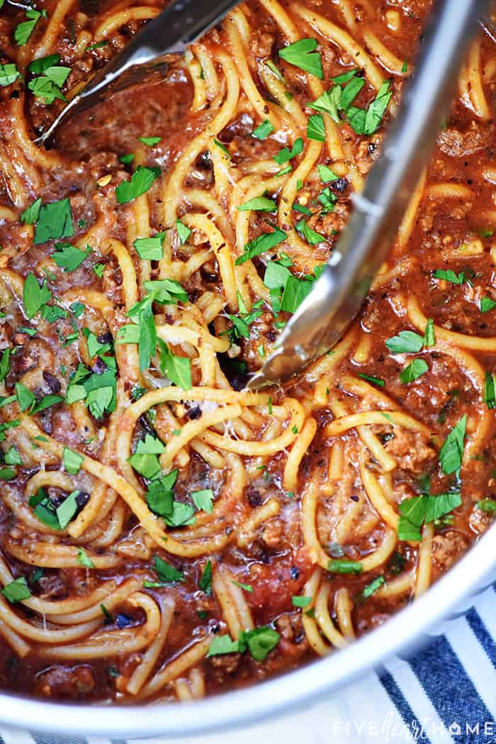 Aerial view of tongs in pot of One Pot Spaghetti.