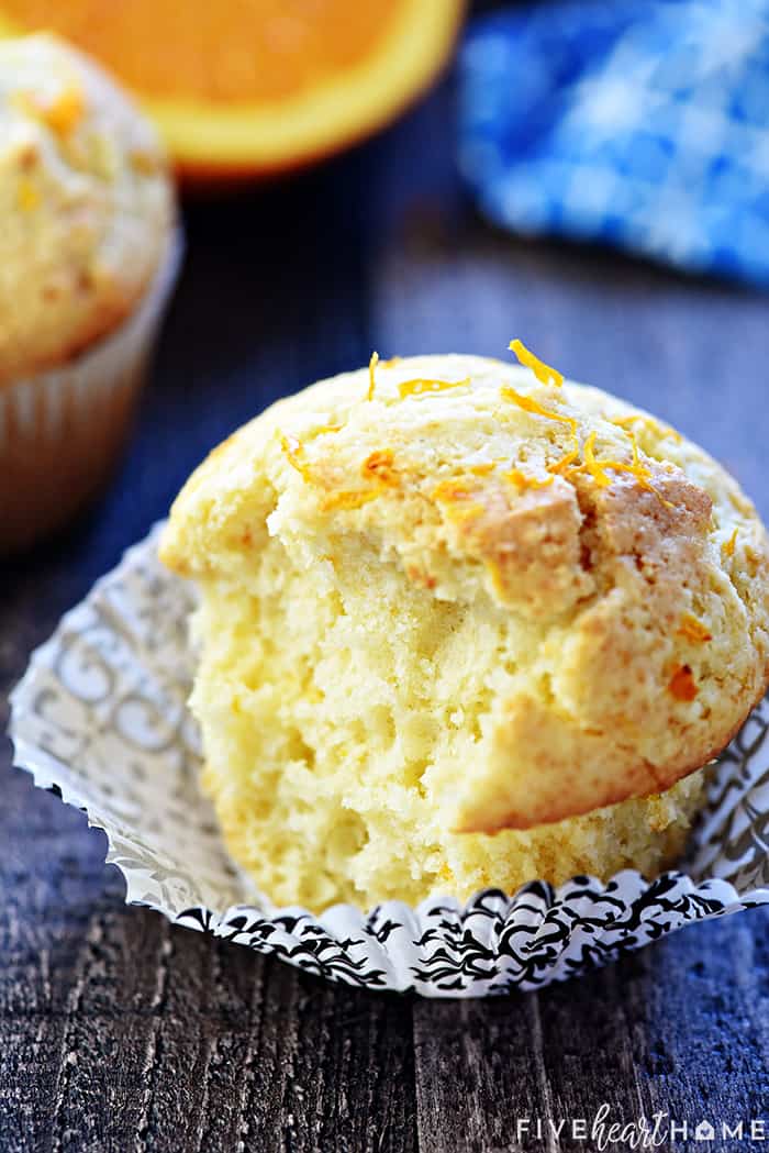 Orange Muffins ~ these lovely muffins are tender, and easy to make from scratch, with delicate flavors of vanilla and citrus from fresh orange juice and zest! | FiveHeartHome.com Orange Muffin with a bite missing.