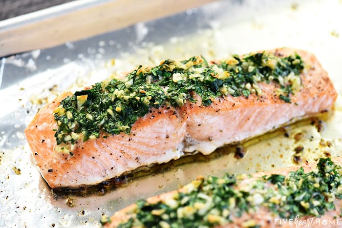 Oven Baked Salmon fillet on sheet pan with garlic and parsley.