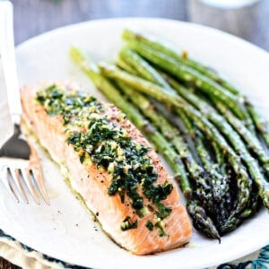 Oven Baked Salmon with Garlic and Parsley on plate with asparagus.