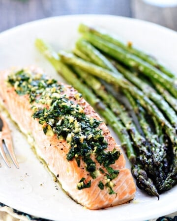 Oven Baked Salmon with Garlic and Parsley on plate with asparagus.
