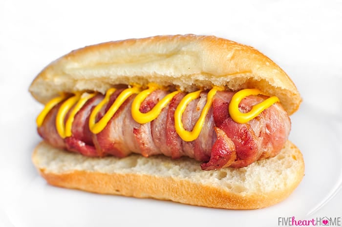Bacon Wrapped Hot Dogs with Cheese ~ cooked on the grill, this recipe takes a summertime staple to the next level...it's sure to be a hit at any party or barbecue! | FiveHeartHome.com #hotdogs Bacon Wrapped Hot Dogs with Cheese on a bun