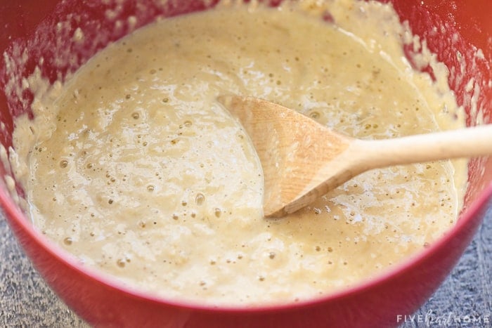 Batter in a red bowl with a wooden spoon