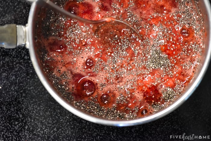 Stirring the chia seeds into the berries to make jam.