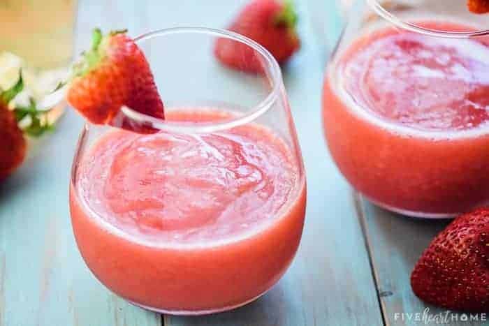 Glasses of frose with fresh strawberries on table