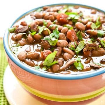 Slow Cooker Charro Beans ~ flavored with bacon, garlic, tomatoes, green chiles, jalapeños, cilantro, and spices, this crock pot recipe is the perfect side dish for Mexican food! | FiveHeartHome.com